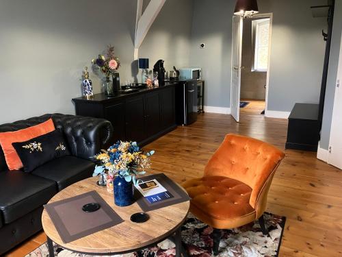 a living room with a couch and a table and a chair at Villa Morton - Domaine du Grand Tourmalet Pic du Midi in Bagnères-de-Bigorre