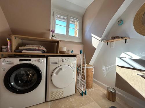 - une buanderie avec un lave-linge et un sèche-linge dans l'établissement Confortable T3 juste rénové au cœur d’Aurillac, à Aurillac