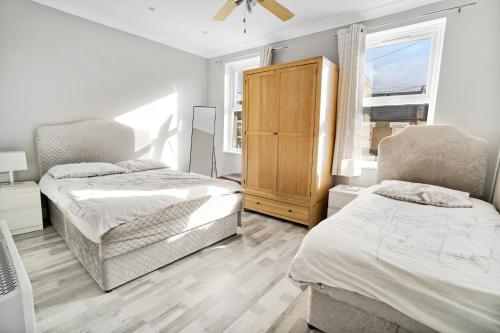 1 dormitorio con 2 camas y vestidor en 7 Bedroom house with Garden, en Londres