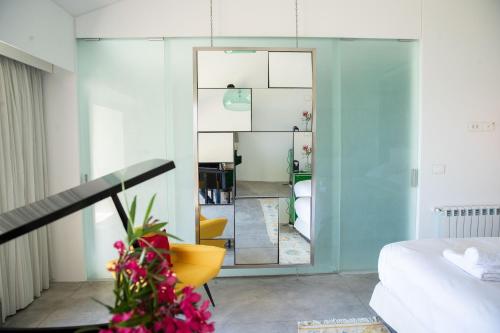 1 dormitorio con espejo y silla amarilla en Zita Fidar en Fidâr
