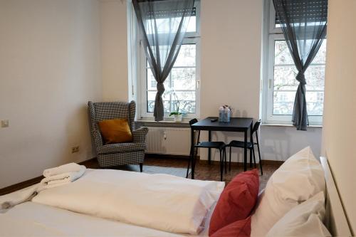 1 dormitorio con 1 cama y 1 mesa con silla en Charmante Altstadtwohnung im Zentrum, en Coblenza