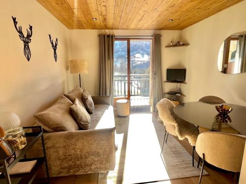a living room with a couch and a table at Nid de charme au pied des pistes in Saint-Martin-de-Belleville