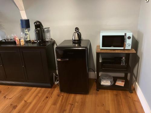 a kitchen with a refrigerator and a microwave on a table at Villa Morton - Domaine du Grand Tourmalet Pic du Midi in Bagnères-de-Bigorre