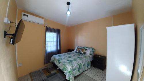 a small bedroom with a bed and a window at Southern Haven Cabin in Laborie