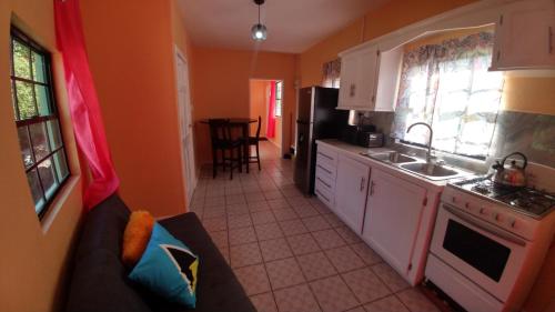 a kitchen with a couch and a stove top oven at Southern Haven Cabin in Laborie