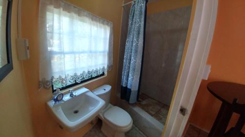 a bathroom with a toilet and a sink and a shower at Southern Haven Cabin in Laborie