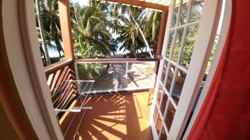 an open door to a balcony with palm trees at Southern Haven Cabin in Laborie