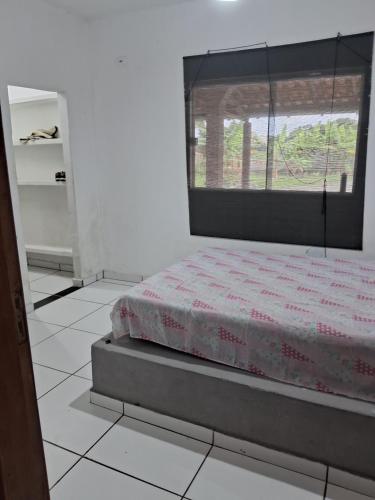 Bett in einem Zimmer mit Fenster in der Unterkunft Sitio in Itapoa