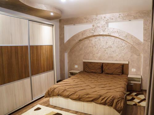 a bedroom with a bed with a stone wall at Residence Apartments Deva in Deva