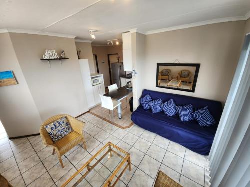 a living room with a blue couch and a chair at SurfBay Sands 65 in Shelly Beach