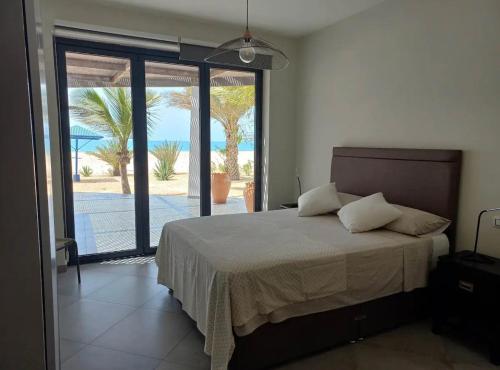 a bedroom with a bed and a view of the ocean at Luxury Beach Villa, Praia de Chaves, Boa Vista in Boa Ventura