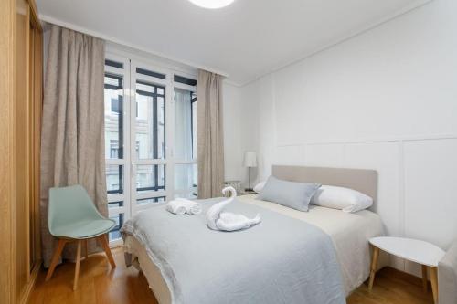 una camera da letto con un letto bianco e un cigno sopra di Céntrico y acogedor by CABANA Rentals a Vigo