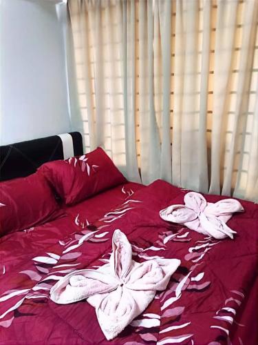 a red bed with white towels on top of it at Bidadari Lagoon 4 Islamic Homestay in Port Dickson