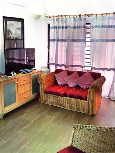 a living room with a red couch and a television at Bidadari Lagoon 4 Islamic Homestay in Port Dickson