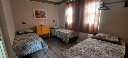 a room with two beds and a dresser in it at Pousada Palmeira in Viracopos