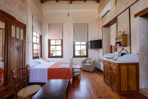 Il comprend une chambre avec un lit et une cuisine avec un évier. dans l'établissement Anassa Townhouse, In Rethymno's old city center, à Réthymnon