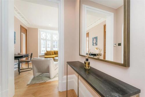 ein Wohnzimmer mit einem Spiegel und einem Tisch in der Unterkunft Marble Arch £2.6million apartment sleeps up to 6 in London