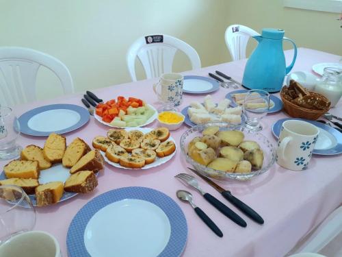 einen Tisch mit Teller und Schüsseln mit Essen drauf in der Unterkunft Pousada Raio de Sol - Ilha de Itaparica- Catu á 150 m da praia in Vera Cruz de Itaparica