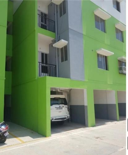 un edificio verde con un coche aparcado en un aparcamiento en Astha Homes, en Lucknow