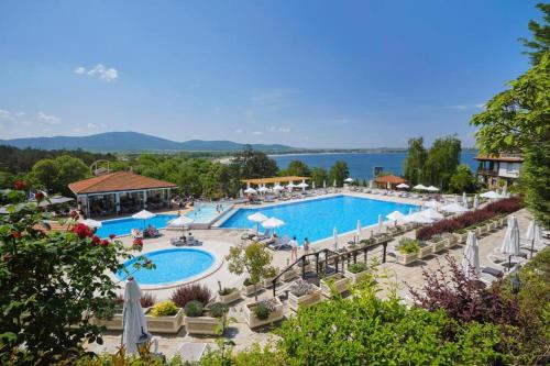 um resort com uma grande piscina com cadeiras e guarda-sóis em Санта Марина-Сладка къща em Sozopol