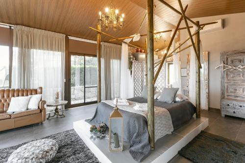 a bedroom with a canopy bed and a couch at Casas da Gralha in Turquel