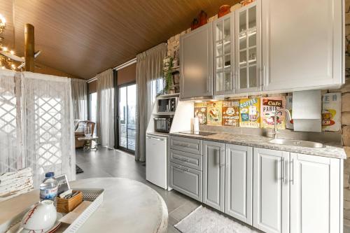 a kitchen with white cabinets and a table at Casas da Gralha in Turquel