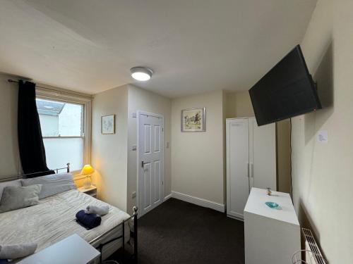 a bedroom with a bed and a flat screen tv at Comfortable home, town centre, free parking,Multiple Rooms in Cheltenham