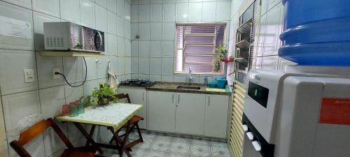 una pequeña cocina con fregadero y mesa en Pousada Palmeira, en Viracopos