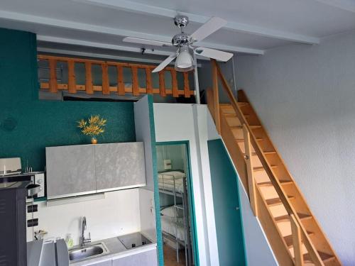 Il comprend une cuisine avec un escalier et un ventilateur de plafond. dans l'établissement La Désirade I, Studio mezzanine, centre port, au Cap d'Agde