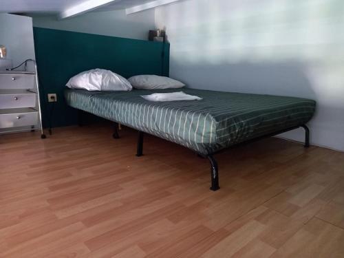 un lit avec deux oreillers dessus dans une chambre dans l'établissement La Désirade I, Studio mezzanine, centre port, au Cap d'Agde