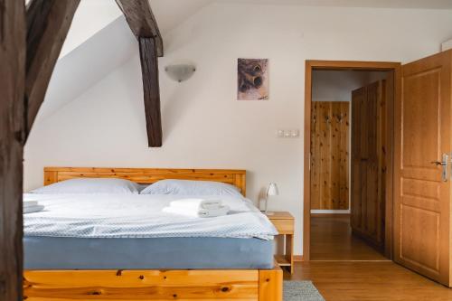 um quarto com uma cama e uma cabeceira em madeira em Apartmán V PODKROVÍ em Horní Planá