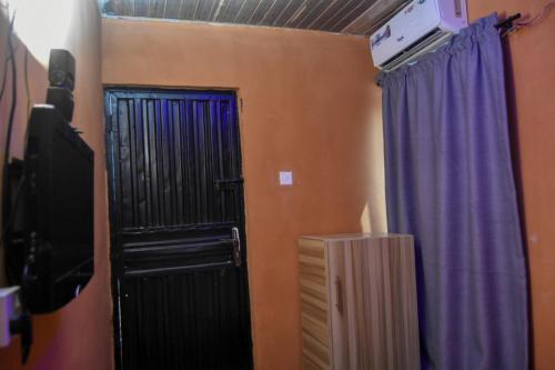 a room with a black door and a purple curtain at More Point Lounge in Ikorodu