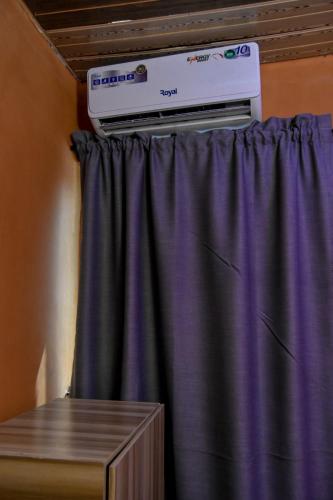 a room with a purple curtain and a heater at More Point Lounge in Ikorodu