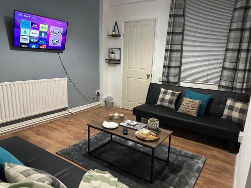 a living room with a couch and a table at Robin Hood House in Nottingham