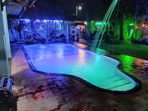ein Pool mit grüner Beleuchtung in der Nacht in der Unterkunft Palms Villa in Negombo