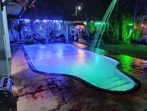 a swimming pool at night with green lights at Palms Villa in Negombo