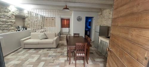 un soggiorno con divano, tavolo e sedie di Via Mazzini Home a Gubbio