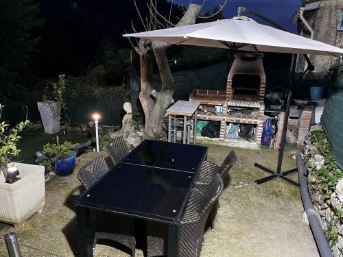 a table and chairs with an umbrella in a yard at Petit coin de paradis in Menton