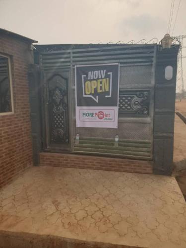 ein nun offenes Schild an der Seite eines Gebäudes in der Unterkunft More Point Lounge in Ikorodu