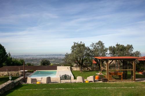 a backyard with a pool and a gazebo at Casas da Gralha in Turquel