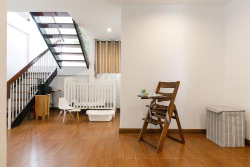 a living room with a chair and a staircase at Villa w/ Pool-Nimman(near Maya) Chiangmai by Fahsai in Chiang Mai