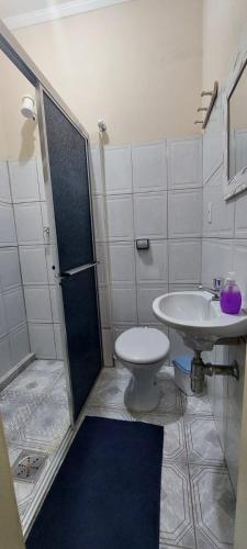 a bathroom with a shower and a toilet and a sink at Pousada Palmeira in Viracopos