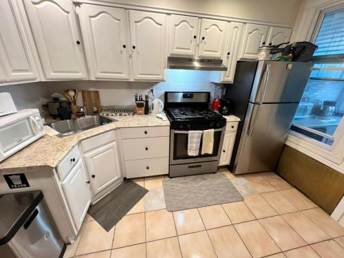 a kitchen with white cabinets and a stainless steel refrigerator at 7-A Diamond in Yonkers in Yonkers