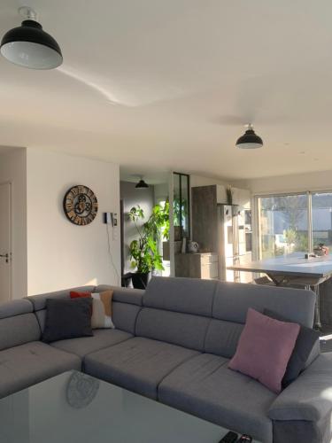un salon avec un canapé et une horloge au mur dans l'établissement Golfe du Morbihan, à Ploeren