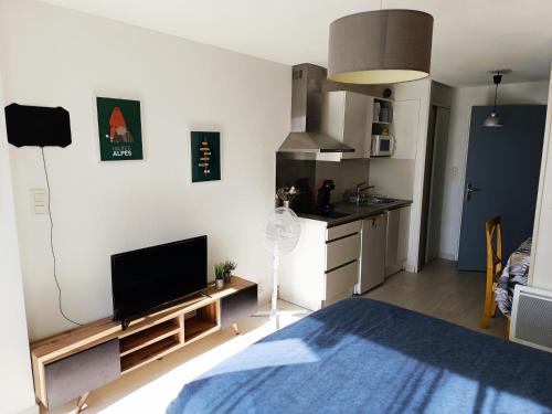 un salon avec un lit et une cuisine dans l'établissement Entre Lac et Montagne - Piscine & Tennis, à Prunières