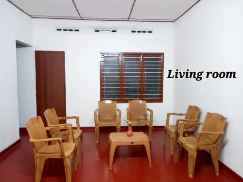 una stanza con sedie e tavolo e un soggiorno di Kilner Lane Guest House a Jaffna