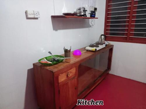 a kitchen with a wooden counter in a room at Kilner Lane Guest House in Jaffna