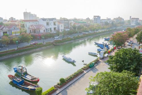 a river with boats docked in a city at 68 ĐỒNG HẢI HOTEL in Dong Hoi