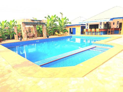 a swimming pool with blue water in a resort at Blue Palm Resort Ghana in Abia