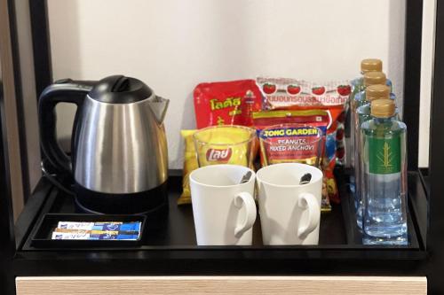 a counter with cups and other items on it at City Park Hotel Bangkok Pratunam by PCL in Bangkok